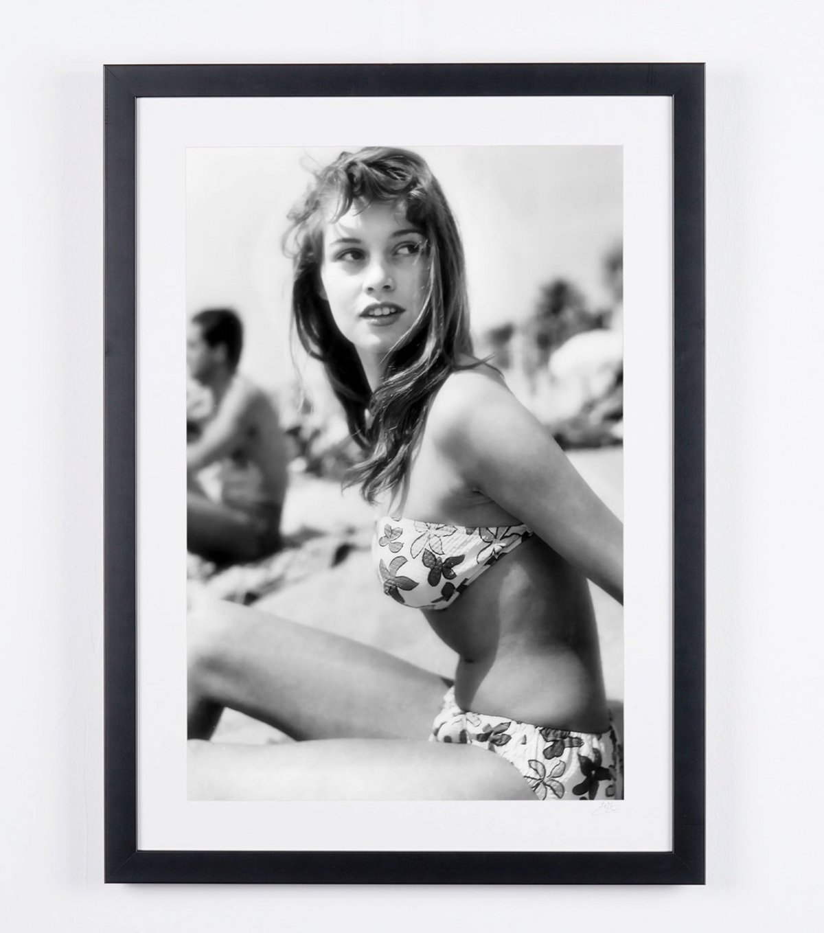 Photographie d’art de Brigitte Bardot dans Brigitte Bardot (Cannes, 1956) — sur le sable, en bikini à fleurs, encadrée à la main — édition limitée de 30 exemplaires numérotés.