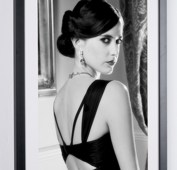 Eva Green in James Bond 007 : Casino Royale (2006), in een jurk met open rug en opgestoken haar, over haar schouder kijkend, ingelijste filmfoto in zwart-wit, detail van de foto en het passe-partout.