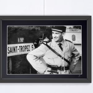 Le Gendarme de Saint-Tropez (1964) - Louis de Funès (Cruchot), at the Saint-Tropez road sign — framed cinema photograph