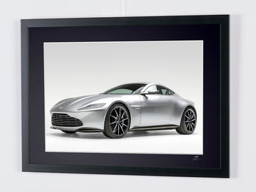 James Bond 007 : Spectre (2015) — Aston Martin DB10, car seen from a front three-quarter angle against a pale background, framed cinema photograph in colour, frame viewed at an angle from the left.