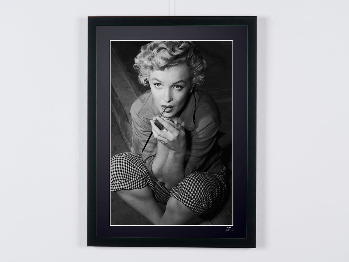 Marilyn Monroe (1948), sitting with a hand near her lips, framed cinema photograph in black and white, front view.